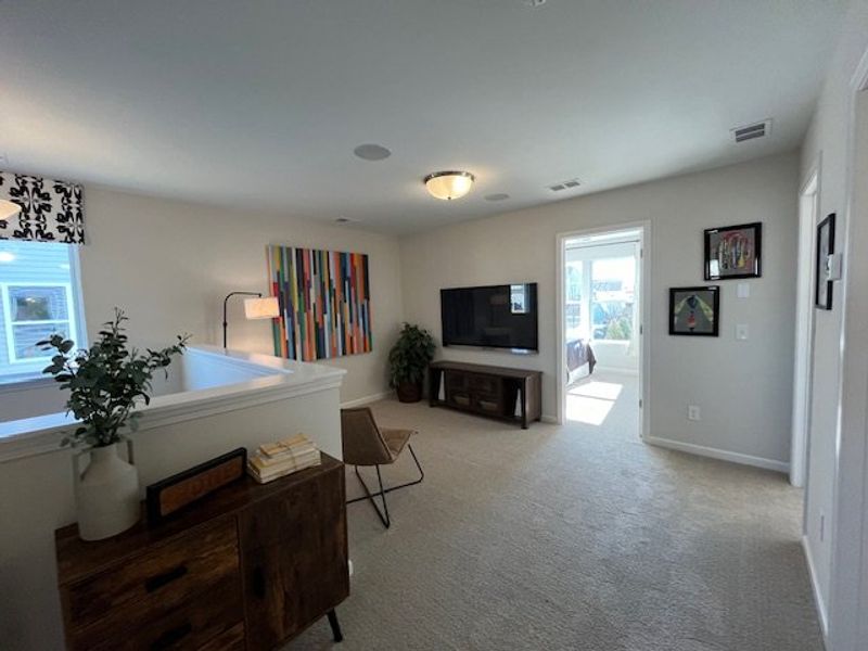 Bright and airy living area with colorful art, modern furniture, and natural light streaming through large windows.