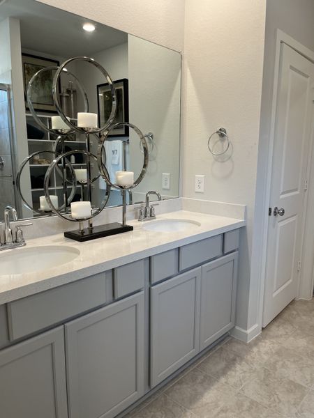 A modern bathroom features a sleek dual-sink vanity with elegant fixtures and stylish decor accents.