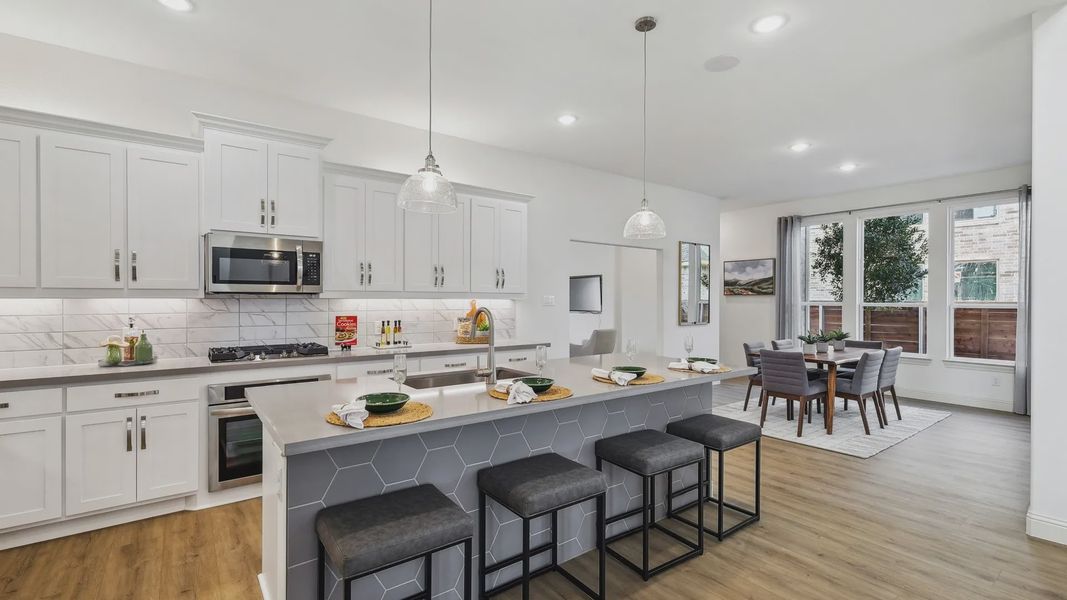 Elegantly designed with hexagon tile island and chic pendant lighting, this Solterra kitchen offers luxury and style.