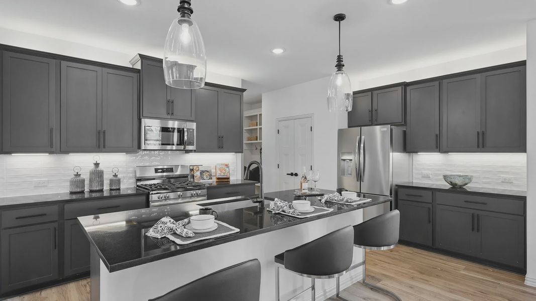 Sleek dark cabinetry and granite countertops highlight this stylish Westridge kitchen masterpiece.