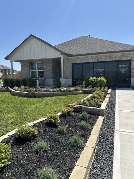 A charming brick home with manicured gardens at Sundance Cove by Davidson Homes LLC (Crosby, TX).