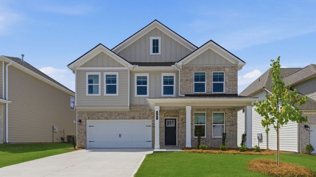 Beautiful two-story brick home in Abbotts Crossing, featuring manicured lawn, covered entry, and spacious two-car garage.