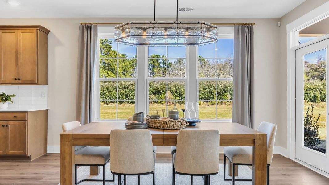 open concept dining room in Chestnut Farms in by DRB homes offering wood floors and lots of natural light