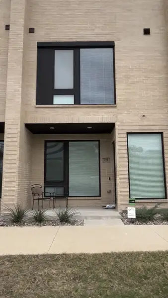 A modern brick townhouse with sleek windows in The Commons at Spring Creek by Centre Living Homes (Richardson, TX).