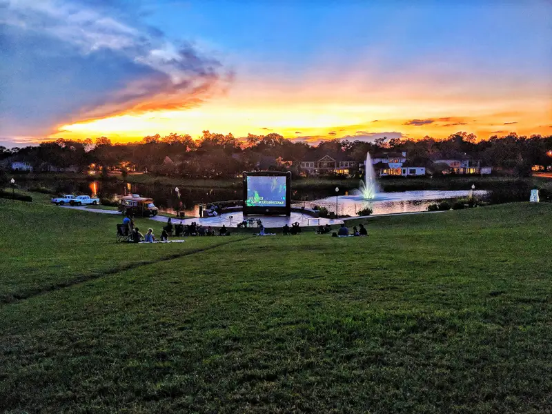 A serene lakeside community with an outdoor movie night at sunset in Sienna 65' by Shea Homes (Missouri City, TX).