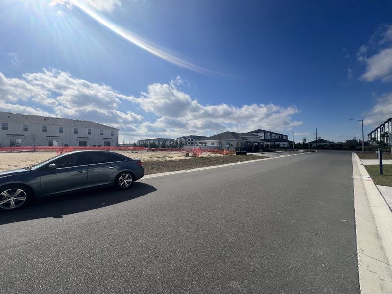 A developing neighborhood street scene in Danbury at Ridgewood Lakes by D.R. Horton, Davenport, FL with clear skies.