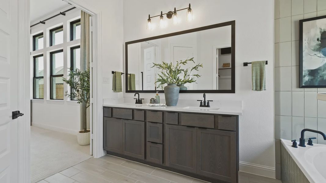 Luxurious dark wood vanity complements chic fixtures in Oakwood Estates. Luxurious dark wood vanity complements chic fixtures in Oakwood Estates.