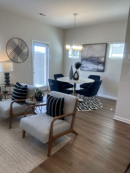 A modern dining and living area with elegant decor, wood flooring, and chic furniture, creating a cozy, stylish ambiance. A modern dining and living area with elegant decor, wood flooring, and chic furniture, creating a cozy, stylish ambiance.