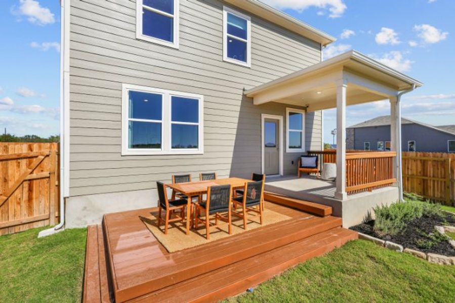 A house with a deck and chairs.