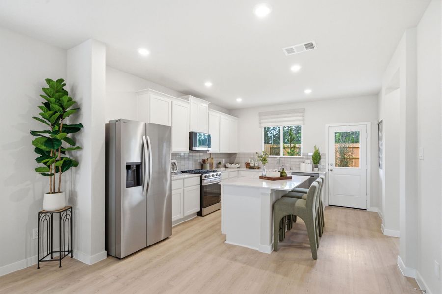 A kitchen with white cabinets.