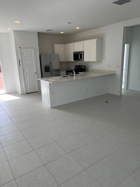 A modern kitchen with sleek white cabinets, spacious counters, and ample natural light. A modern kitchen with sleek white cabinets, spacious counters, and ample natural light.