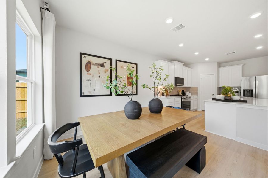 A kitchen with a table and chairs.