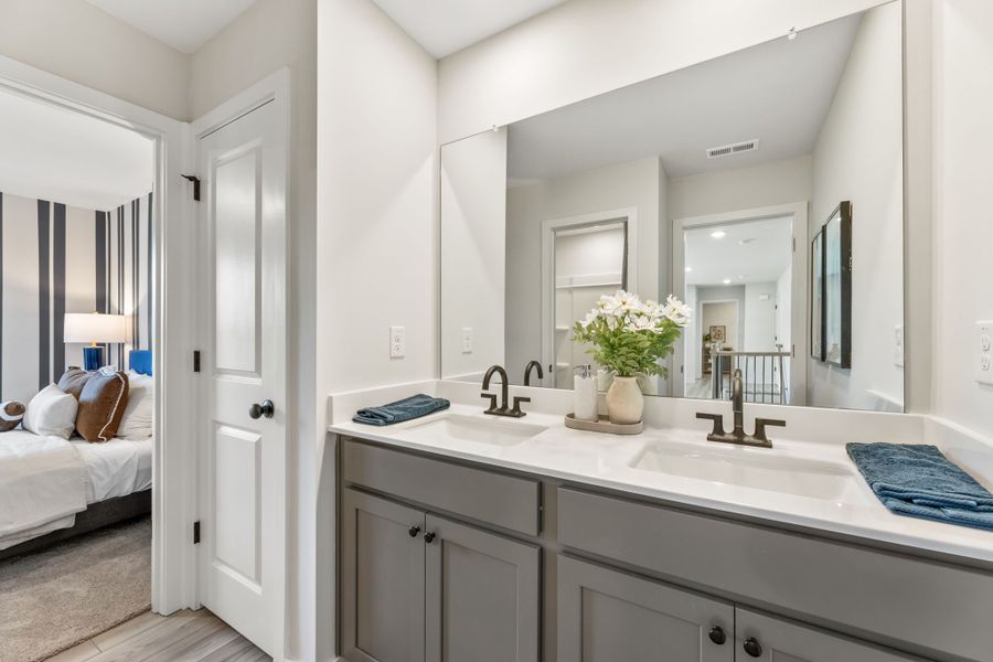 A bathroom with a sink and a bed.