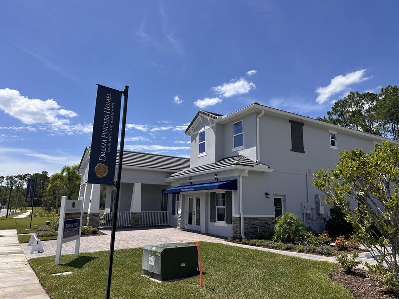 A modern white home with a neat yard in Palms at Windermere by Dream Finders Homes, Windermere, FL.