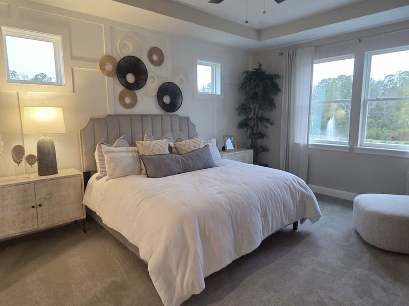 A cozy bedroom with a tufted headboard, modern wall art, and soft lighting, overlooking serene greenery through large windows. A cozy bedroom with a tufted headboard, modern wall art, and soft lighting, overlooking serene greenery through large windows.