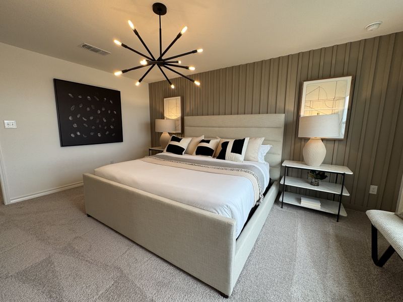 A modern bedroom with a plush bed, unique chandelier, textured accent wall, and sleek decor for a cozy and stylish retreat.
