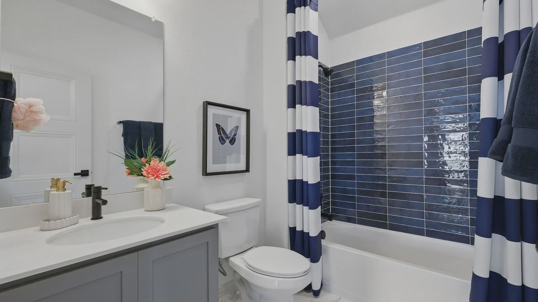 Luxurious Westridge bathroom features navy tiles, chic striped curtains, and a sleek modern vanity.