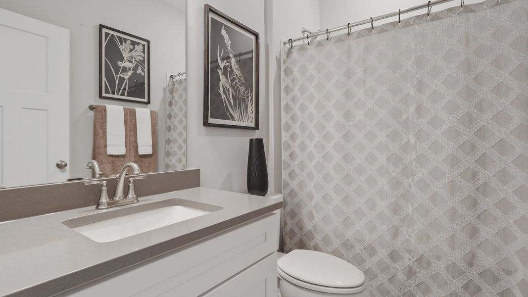 Secondary bathroom with polished nickel accents and colored countertops at Walnut Ridge by DRB Homes in Inman, SC