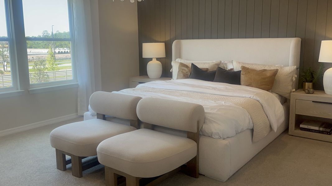 A cozy bedroom featuring an elegant upholstered bed, soft beige chairs, and stylish modern decor. A cozy bedroom featuring an elegant upholstered bed, soft beige chairs, and stylish modern decor.