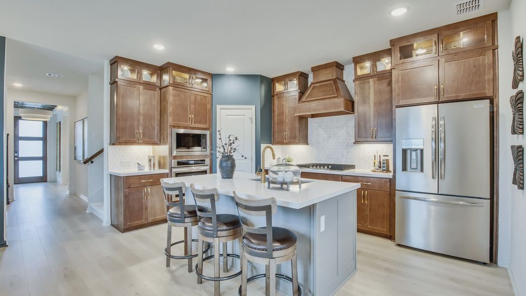 Elegant Opal Ranch kitchen features premium wood cabinetry and exquisite marble surfaces.