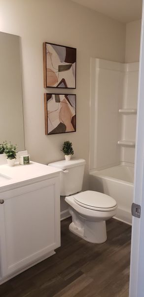 A modern bathroom with sleek white cabinetry, abstract art, and a cozy tub for a stylish touch. A modern bathroom with sleek white cabinetry, abstract art, and a cozy tub for a stylish touch.