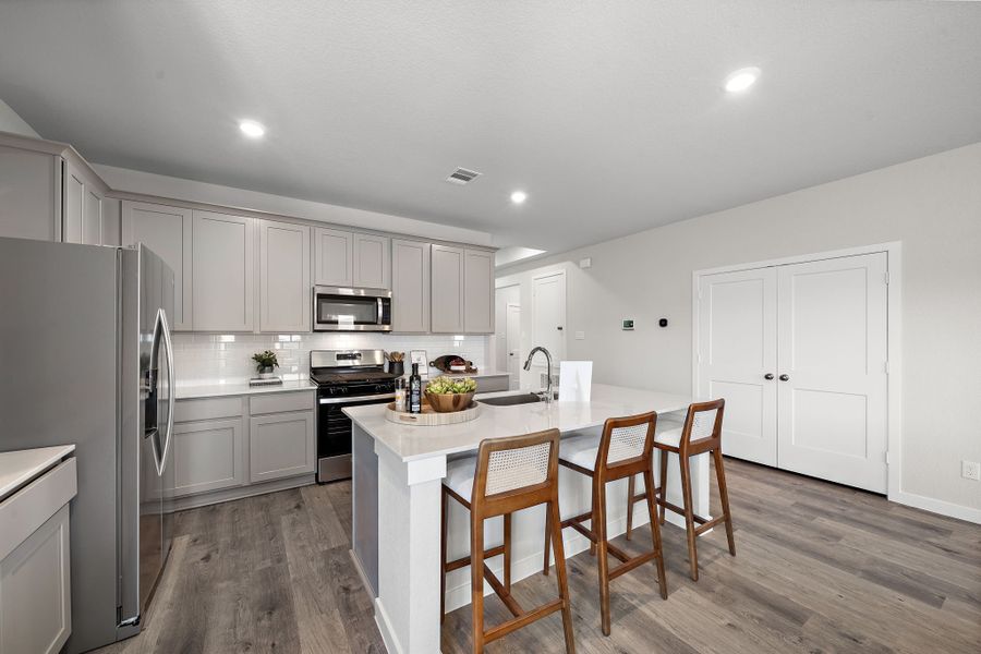 A kitchen with white cabinets.