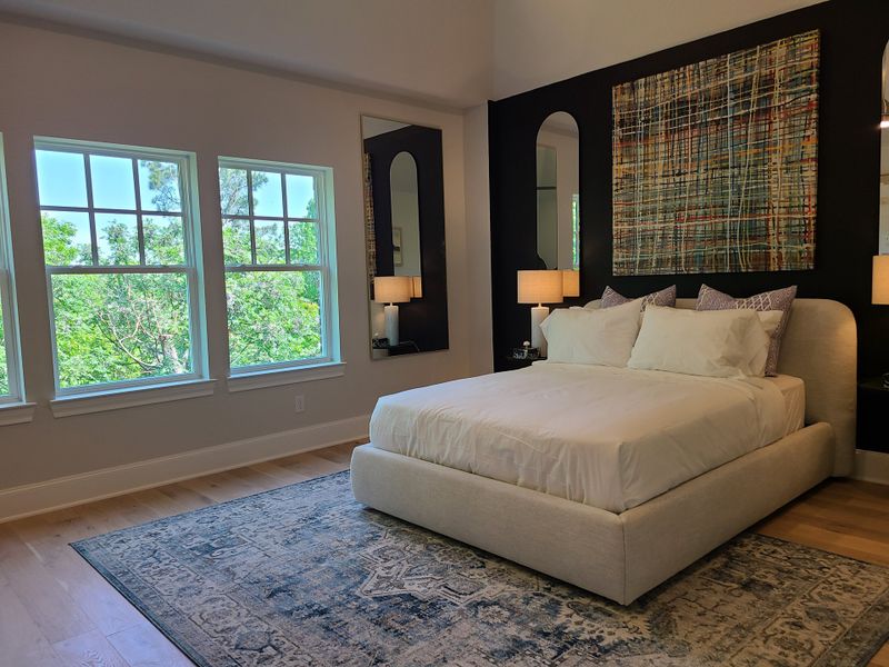 A serene bedroom featuring a plush bed, large windows, modern artwork, and dual mirrors for a stylish ambiance. A serene bedroom featuring a plush bed, large windows, modern artwork, and dual mirrors for a stylish ambiance.