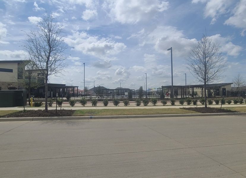 A modern community landscape with open green areas and pathways in Symmetry 37s by Landon Homes (Frisco, TX).