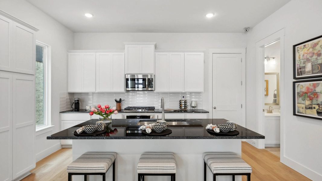 Experience luxury in Collin Creek's kitchen with exquisite granite island and sleek cabinetry. Experience luxury in Collin Creek's kitchen with exquisite granite island and sleek cabinetry.