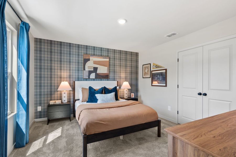 A bedroom with a bed and lamps.