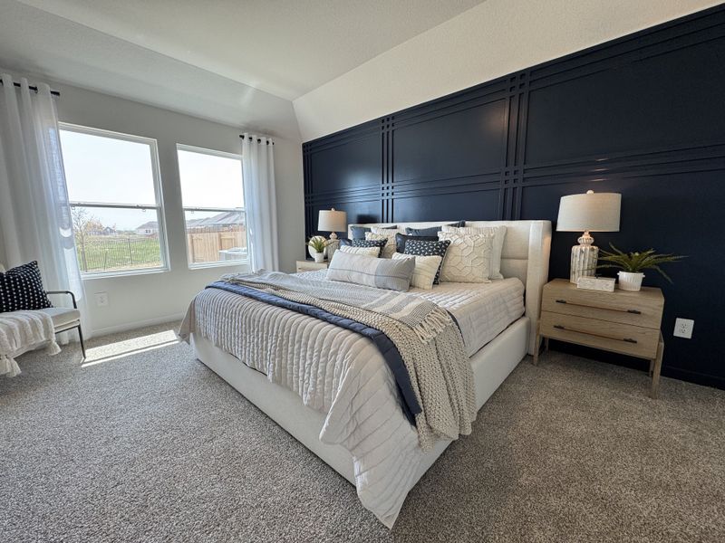 A cozy bedroom with a plush bed, dark accent wall, elegant nightstands, and abundant natural light from large windows. A cozy bedroom with a plush bed, dark accent wall, elegant nightstands, and abundant natural light from large windows.