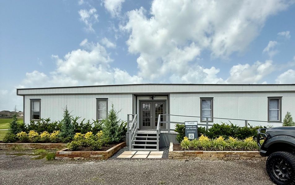A modern, single-story building with a landscaped entrance in Tompkins Reserve by Tri Pointe Homes (Katy, TX). A modern, single-story building with a landscaped entrance in Tompkins Reserve by Tri Pointe Homes (Katy, TX).