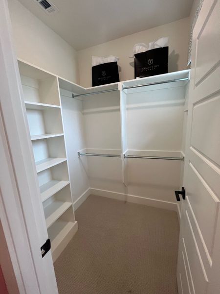 Spacious walk-in closet with open shelving and ample hanging space.