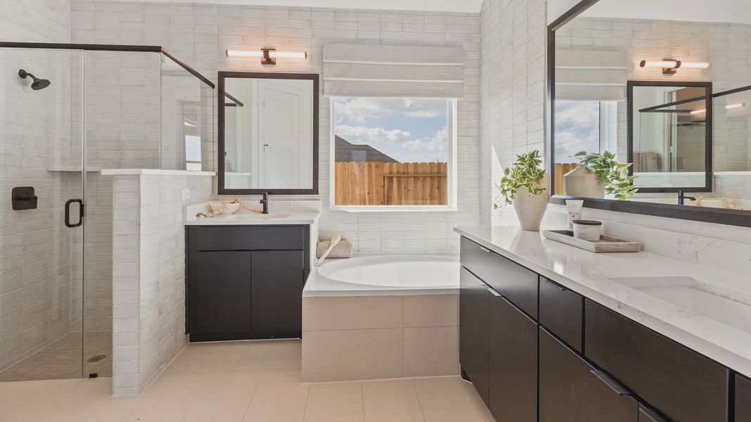 Elegant dark cabinetry, durable tile flooring, and sleek fixtures elevate this River Ranch bathroom retreat.