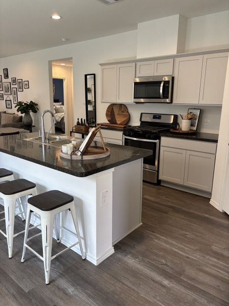 A modern kitchen with sleek cabinetry, stainless steel appliances, and a spacious island with seating.