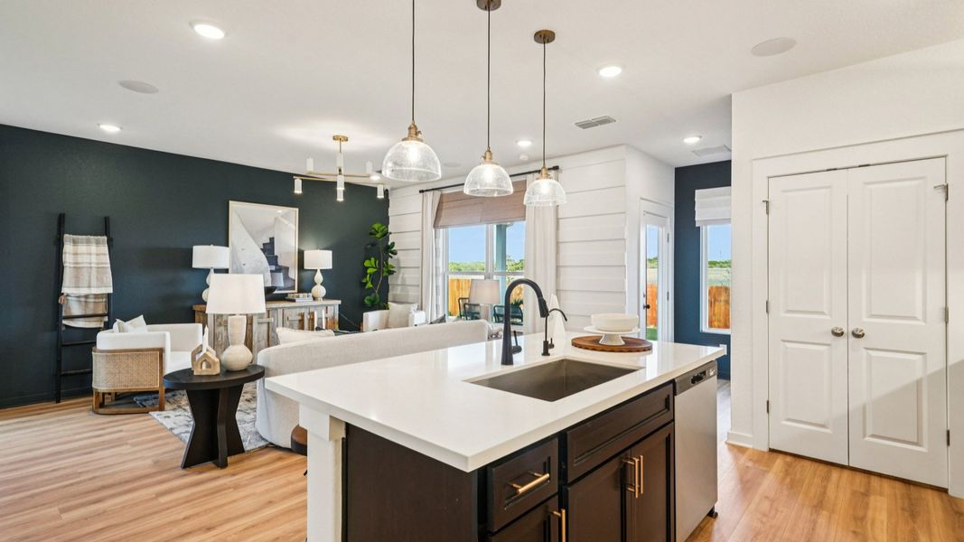 Island Features Omegastone countertops, Stainless Steel Sink, and Pendant Lighting