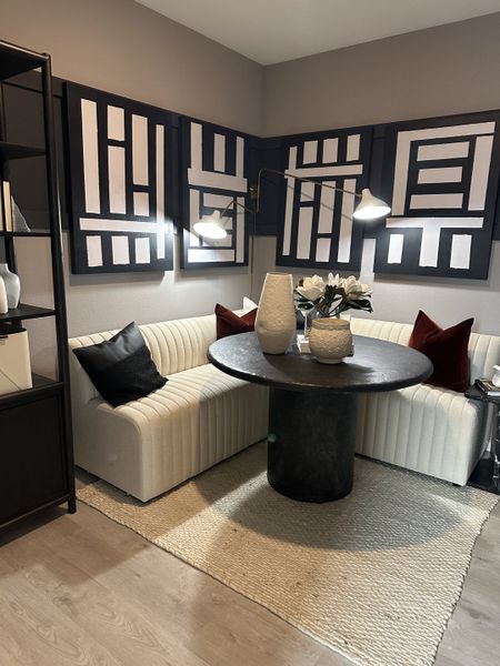A cozy nook with a modern round table, plush seating, abstract wall art, and elegant decor, creating a stylish vibe.
