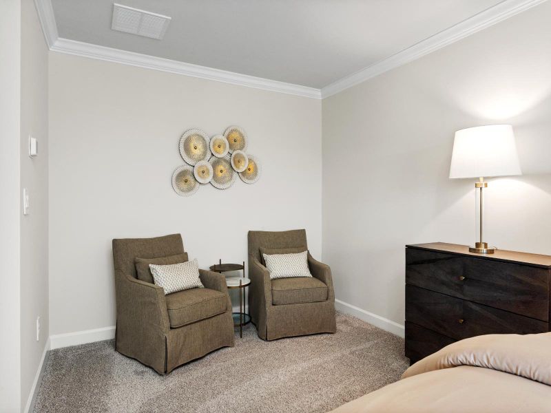 The large primary bedroom provides space for a reading nook or seating area.