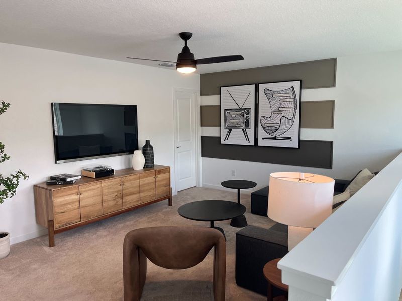 A modern living area with sleek decor, wall art, and a stylish media console under a mounted TV. A modern living area with sleek decor, wall art, and a stylish media console under a mounted TV.