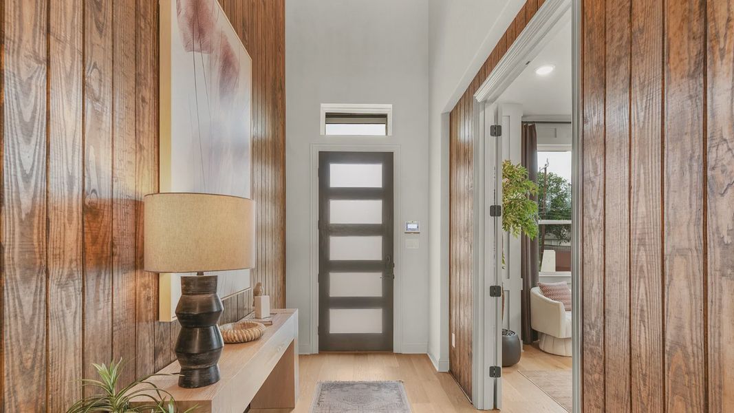 Modern entryway with soaring ceilings, natural light, and sleek finsih.