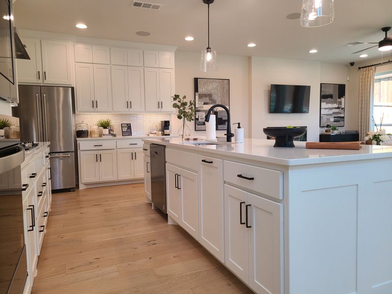 A spacious kitchen with sleek white cabinetry, stainless-steel appliances, and a large island perfect for entertaining. A spacious kitchen with sleek white cabinetry, stainless-steel appliances, and a large island perfect for entertaining.