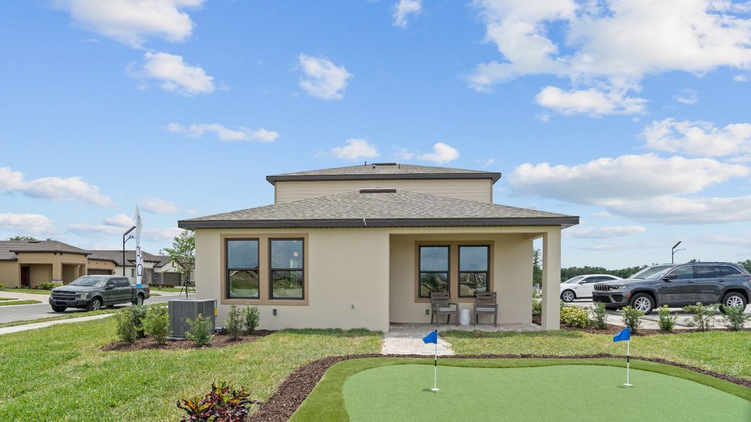 Enjoy a private putting green and covered patio backyard of the Jupiter Model at Grasslands West by DRB Homes in Lakeland, FL