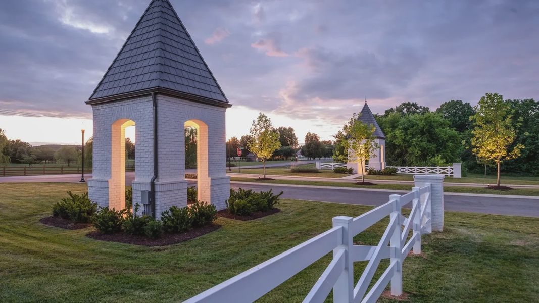 Luxurious white brick towers with slate roofs exude timeless elegance amidst lush Shelton Square landscape.