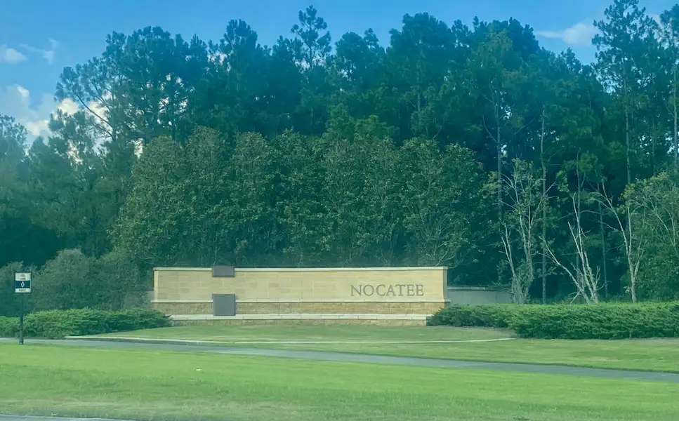 A welcoming entrance sign amidst lush greenery at West End At Town Center In Nocatee by Dostie Homes (Ponte Vedra Beach, FL). A welcoming entrance sign amidst lush greenery at West End At Town Center In Nocatee by Dostie Homes (Ponte Vedra Beach, FL).
