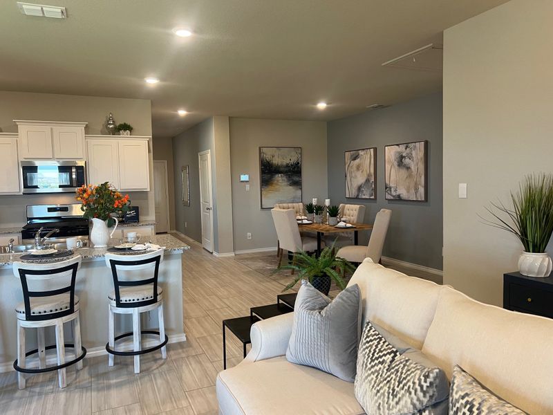 A modern open-plan living area with a sleek kitchen, cozy dining space, and elegant decor. A modern open-plan living area with a sleek kitchen, cozy dining space, and elegant decor.