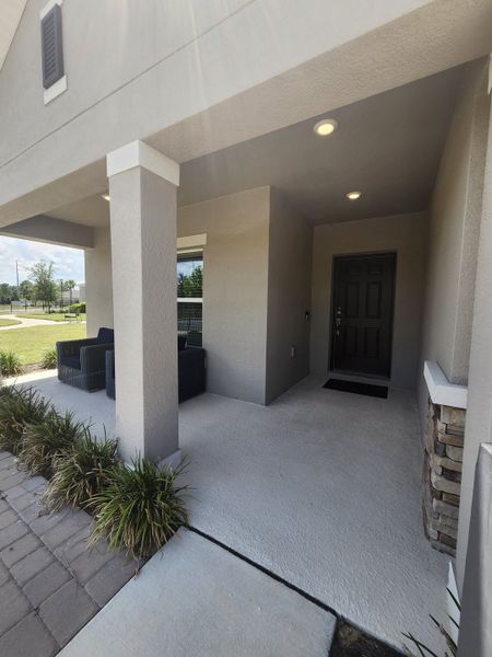 Elegant covered entry with seating area at Marion Creek by Taylor Morrison in Haines City, FL.