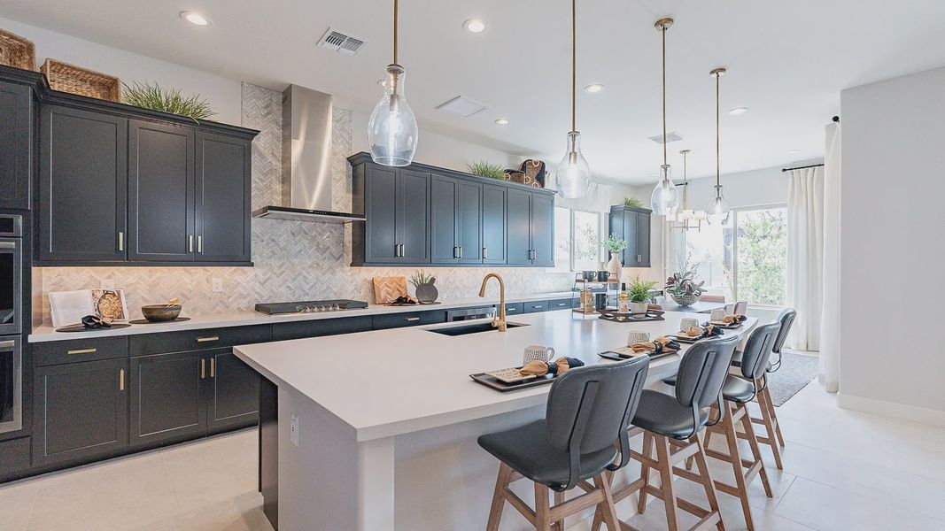 Luxurious kitchen featuring black cabinetry, sleek island, and elegant herringbone tile in Windrose.