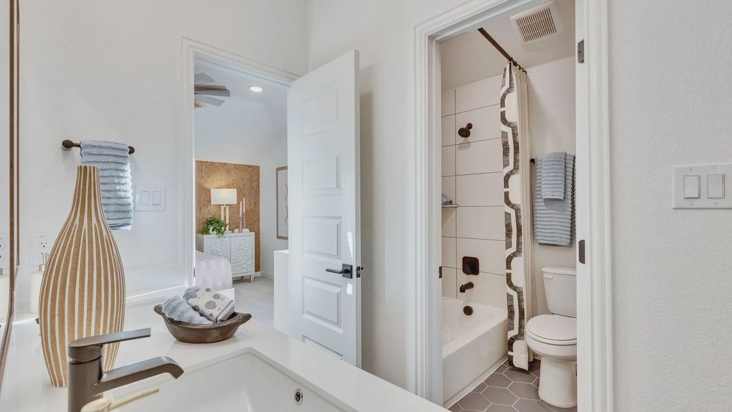 Exquisite hexagonal tile and sleek fixtures in Creeks Crossing enhance modern luxury.