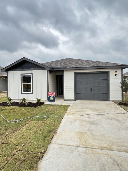 A cozy modern home with a gray garage and manicured lawn in Big Sky Estates by LGI Homes (Ponder, TX).
