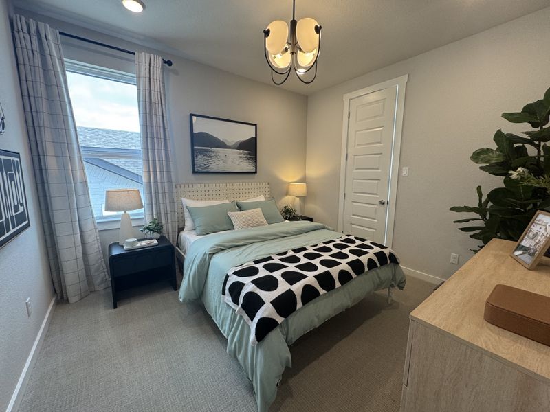 A cozy bedroom with stylish decor, soft green accents, and a chic black-and-white patterned throw for a modern touch.